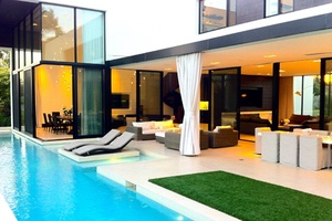 First view of an image of a pool with glass looking into house.