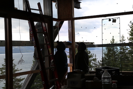 Pro Glass installers installing windows on a new 2021 home in lake tahoe california looking out at the lake.